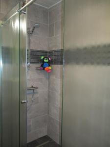 una doccia con un animale di peluche seduta su una mensola in bagno di Adlerhorst a Sellrain