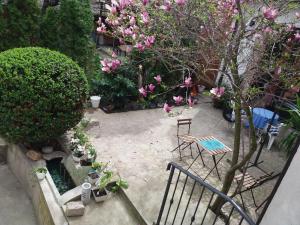 a patio with a table and chairs and pink flowers at Crystal Kragujevac in Kragujevac