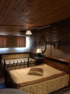 1 dormitorio con 1 cama grande y techo de madera en Apartment Chalet, en Shakhty