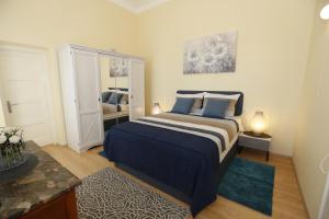 a bedroom with a large bed with blue pillows at Apartment & Rooms Three Angels in Baška