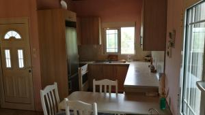 cocina con mesa, sillas y fregadero en Kavouri 2 en Nea Potidaea