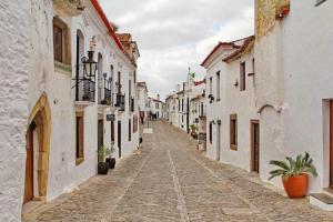 a cobblestone street in a town with white buildings at Casa da tia Bina in Monsaraz