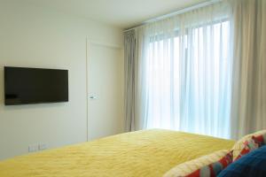 a bedroom with a bed with a television and a window at MyHolidays, Shotover, Delux Ensuite rooms in Queenstown