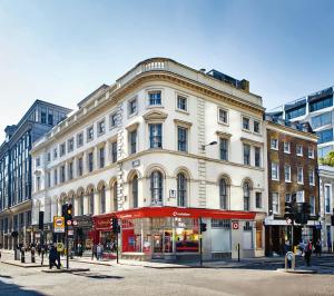 un grande edificio bianco all'angolo di una strada di The Moorgate by COVE a Londra