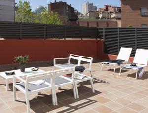 un groupe de chaises et de tables sur un toit dans l'établissement La casa del Piano, à Figueres