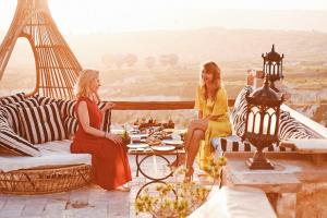 Zwei Frauen sitzen auf einem Tisch vor dem Eiffelturm in der Unterkunft Rox Cappadocia in Uchisar