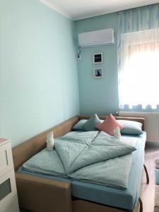 sypialnia z łóżkiem z niebieskimi ścianami i oknem w obiekcie Aquamarin Studio Apartman w Siófoku