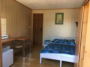 a bedroom with a bed and a desk and a table at Orle Gniazdo domki in Stegna