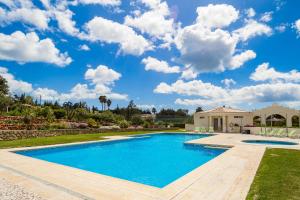 una piscina en un patio con una casa en Quinta do Rosal, Casa Rosa, en Carvoeiro