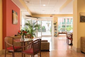 un vestíbulo de un hospital con mesa y sillas en Hotel Elisabetta, en Sestri Levante
