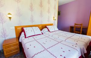 a bedroom with a bed with white sheets and red pillows at Hostal Plaza in Ciudad-Rodrigo +12 photos