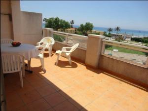 塔瑪莉特的住宿－Cala Azul 304-306 Tamarit，阳台配有桌椅,享有海景。