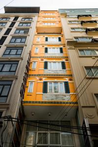um edifício laranja alto com muitas janelas em Ipeace Hotel - Bùi Viện Walking Street em Ho Chi Minh
