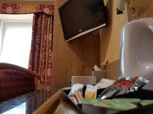 a cluttered desk with a television and a trash can at Shap Wells Hotel in Shap