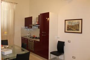 una pequeña cocina con mesa de cristal y encimera en Rome Veniero WelcomeHouse en Roma