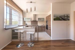 a kitchen with a counter and stools at Apartsee U Ježíška in Plzeň