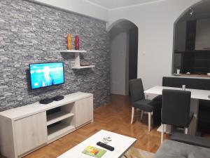 a living room with a tv on a brick wall at Apartment Azzuro 2 in Novi Sad