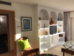 a living room with white shelves and a tv at Cala Azul 304-306 Tamarit in Tamarit