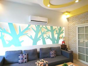 a living room with a couch and a air conditioner on a wall at 懶羊羊民宿Cozy Sheep in Chishang