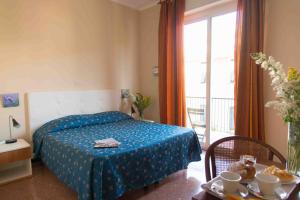 - une chambre avec un lit doté d'une couverture bleue et d'une fenêtre dans l'établissement Hotel Elisabetta, à Sestri Levante