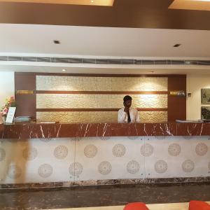 a man standing behind the counter of a restaurant at Grand Gardenia in Tiruchchirāppalli