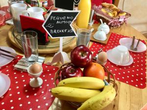 a table with apples and bananas and a basket of fruit at Casa de férias Josefa D´Óbidos in Óbidos