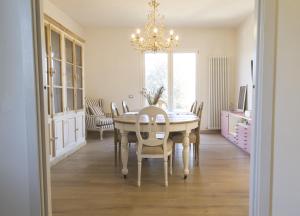 une salle à manger avec une table, des chaises et un lustre dans l'établissement La Rosa dei Sensi Luxury Villa Apt 1, à Montecarlo