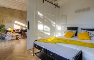 1 dormitorio con 1 cama grande con almohadas amarillas en Verdura Suites ArchSense Apartments, en Pontevedra