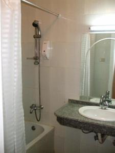 a bathroom with a shower and a sink and a tub at Orchida St. George Hotel in Aswan
