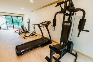 a gym with several exercise bikes and a treadmill at Airport Beach Hotel Phuket - SHA Extra Plus in Nai Yang Beach