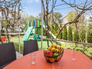 a bowl of fruit on a table with a playground at Maki Apartments - Plavi Horizonti Beach in Tivat