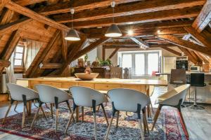 een keuken met een grote houten tafel en stoelen bij Porte des Pucelles in Ribeauvillé