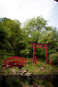 a red gate and a bridge in a park at Casa Lily - Japanese Retreat in Sighişoara