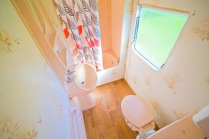 niewielka łazienka z toaletą i oknem w obiekcie Domki Holenderskie Red Ice we Władysławowie