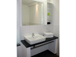un baño con lavabo y espejo en dat witte hus 1, en Büsum 14 fotos más