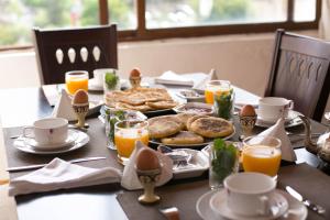 - une table avec des aliments pour le petit-déjeuner et du jus d'orange dans l'établissement Riad Fes Andalucia, à Fès