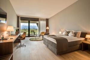 a bedroom with a large bed and a large window at Gasthaus Badhof - Golfhotel in Lucerne