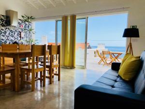 Terra do PãoCasa da Rocha的客厅里有一张蓝色的沙发、一张桌子和几把椅子