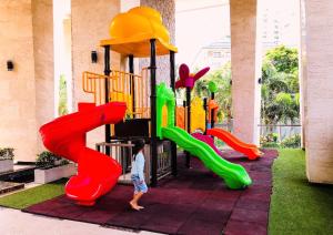 a young boy is playing on a playground at The Peak Towers Pattaya in Pattaya South