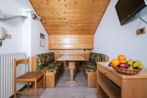 a room with a table and chairs and a bowl of fruit at Appartamenti Bel Sit in Canazei