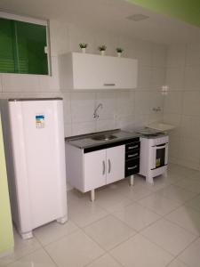 a white kitchen with a sink and a refrigerator at Hotel Letiva Arco in Sobral