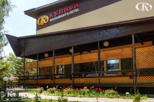 a restaurant with red flowers in front of it at Hotel Complex Kupava in Podvorki