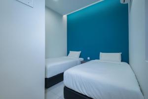 a bedroom with two beds and a blue wall at G3 HOUSE in Johor Bahru