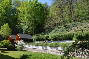 a garden with a red barn and a fence at Penzion Šterk in Most na Soči