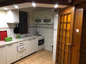 a kitchen with white cabinets and a stove top oven at Central apartment with city view in Prizren