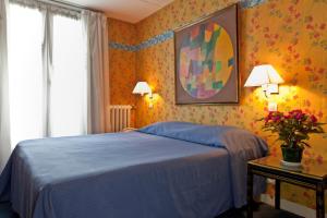 a bedroom with a blue bed and flowers on the wall at Hotel Agora in Paris