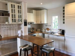 a kitchen with white cabinets and a wooden table at Tamina in Andernos-les-Bains