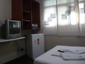 a room with a small refrigerator and a tv at Goias Hotel in Goiânia