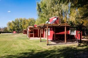 una piccola casa rossa con alberi sullo sfondo di Cabañas El Remanso a Tupungato