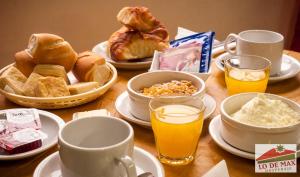 una mesa cubierta con platos de comida y tazas de zumo de naranja en Hospedaje Lo de Max en San Carlos de Bariloche